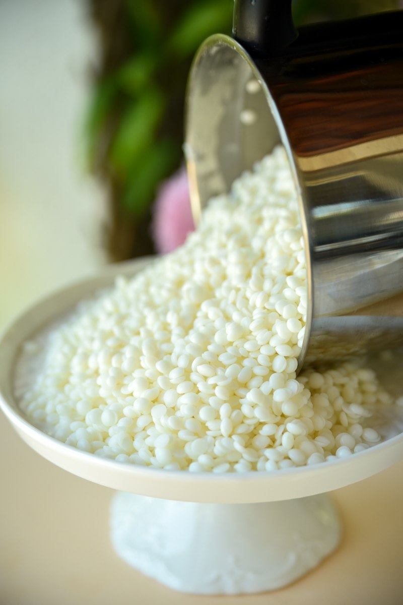 Billes de cire de soja naturelle coulées dans un bol blanc
