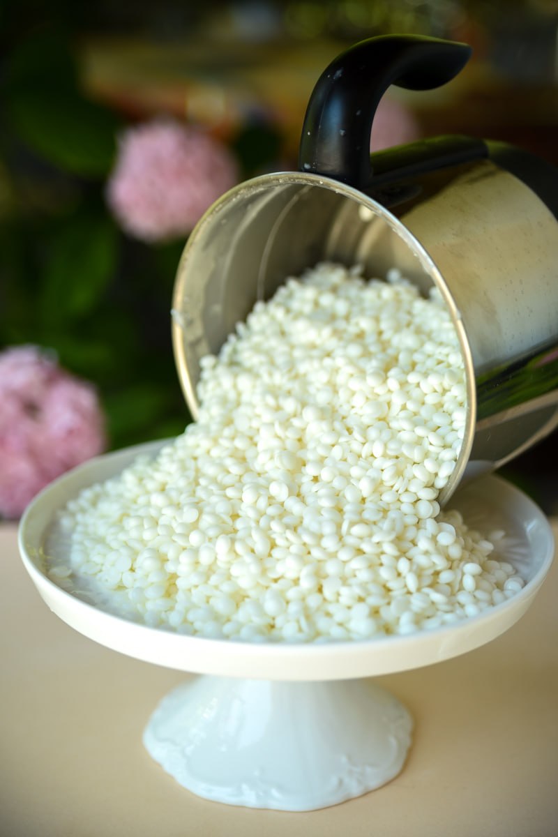 Billes de cire de soja versées dans un contenant artisanal